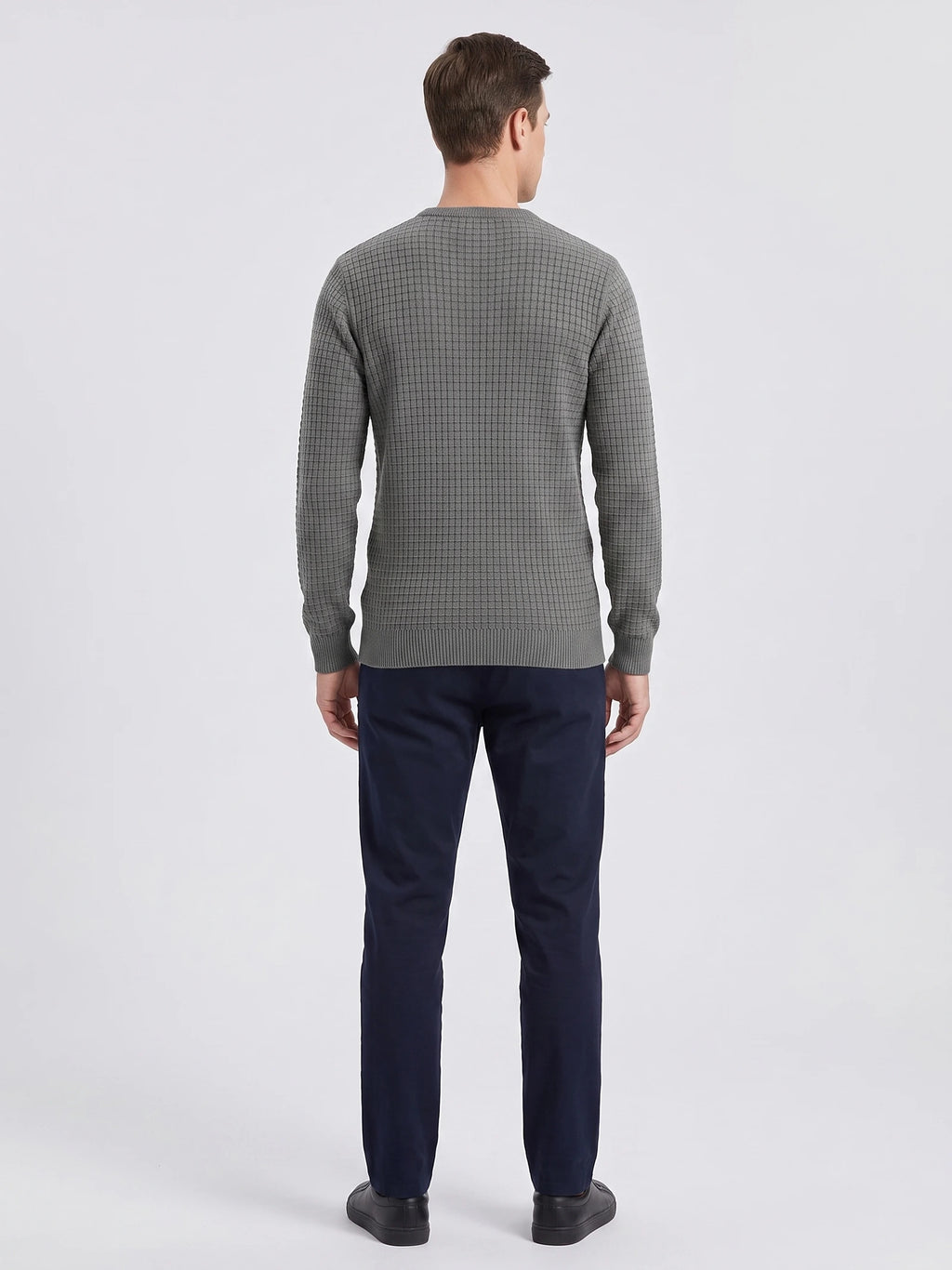 Rear studio view of a model wearing a Gray men's crewneck sweater with a textured grid-knit pattern and ribbed hem and cuffs.