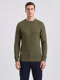 Front studio view of a model wearing a Green men's crewneck sweater with a textured grid knit and ribbed trim.