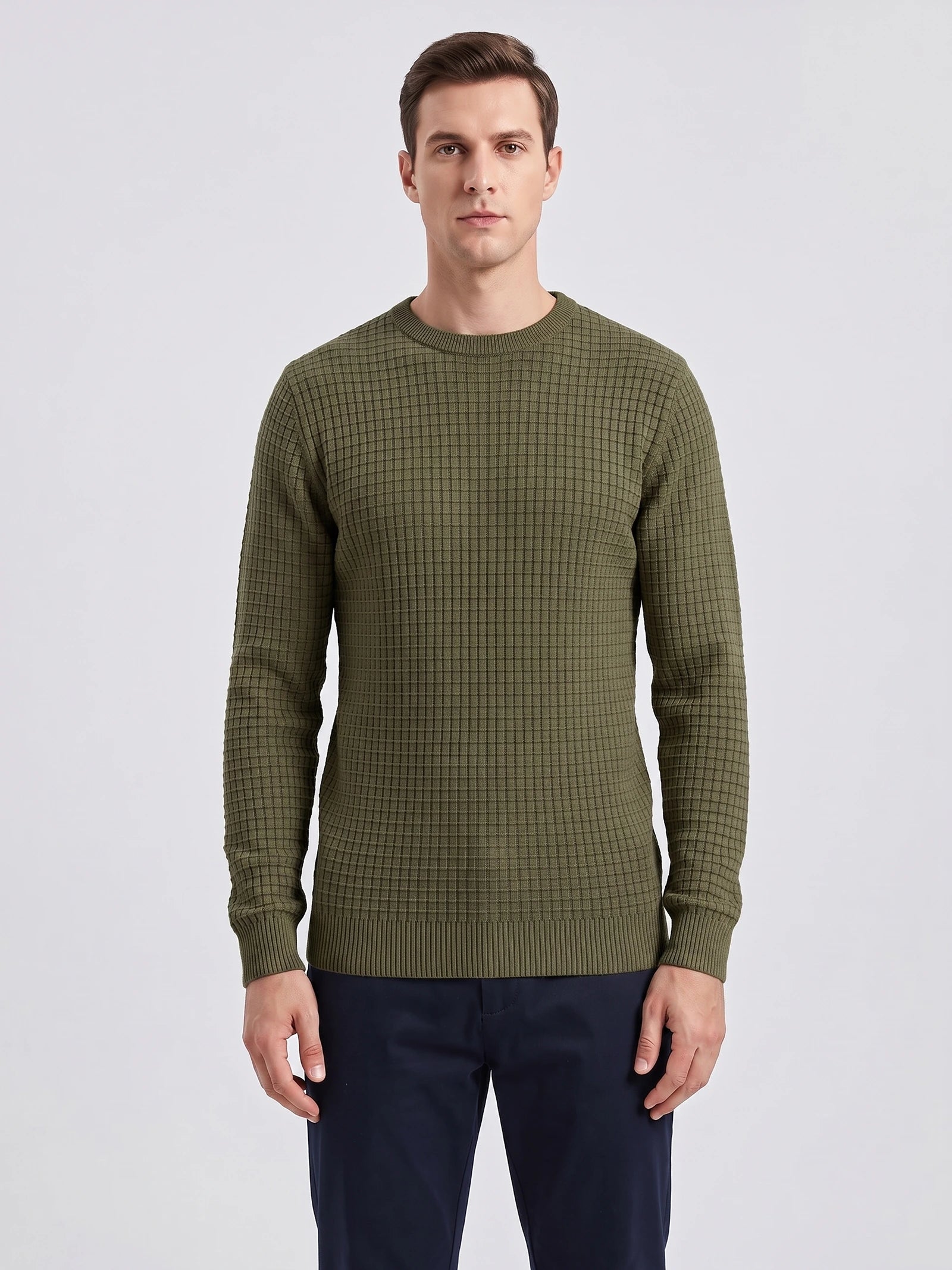Front studio view of a model wearing a Green men's crewneck sweater with a textured grid knit and ribbed trim.