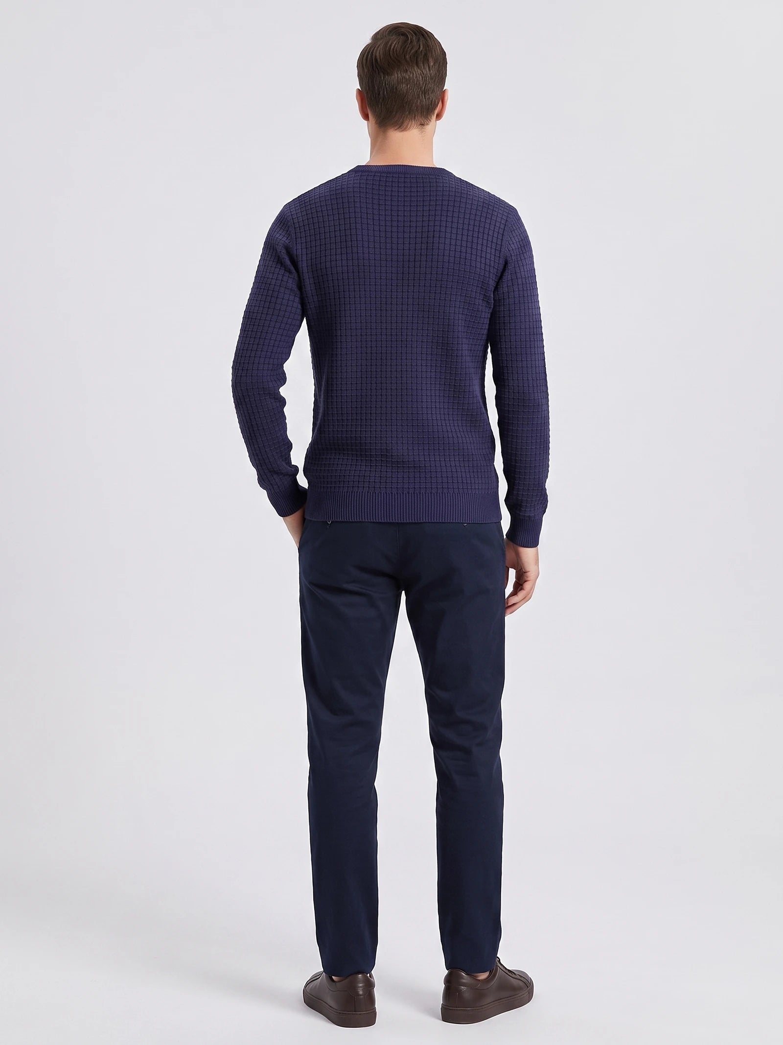 Rear studio view of a model wearing a Navy Men's Crewneck Sweater with textured knit and ribbed hem and cuffs.