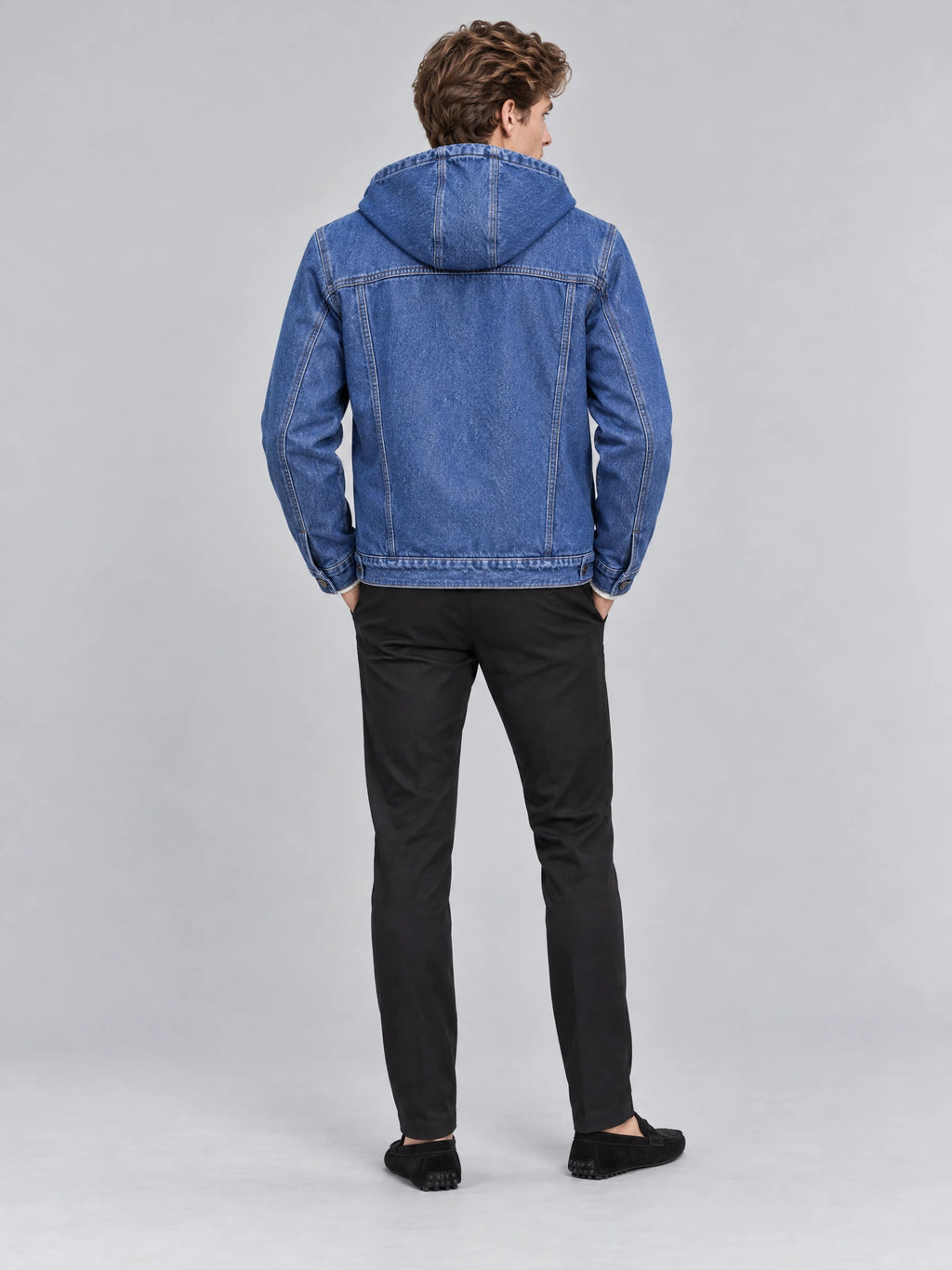 Rear view of a model wearing a Blue mens denim hoodie with a hood and paneled back stitching.