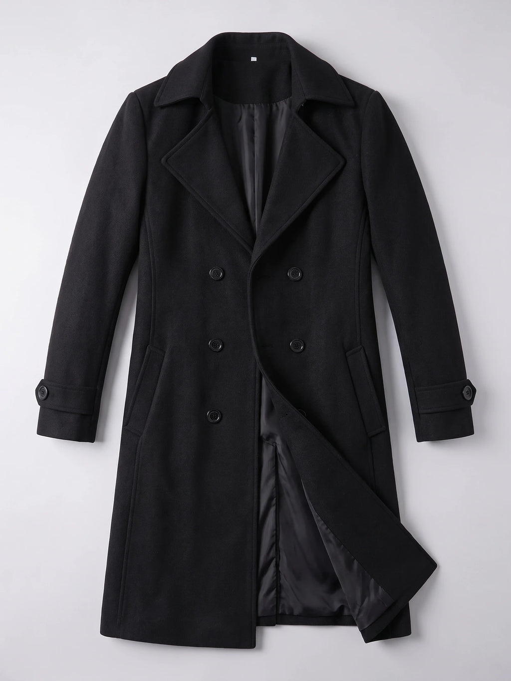 Black double-breasted trench coat laid flat, showing the turn-down collar, buttoned cuffs, flap pockets, and inner lining.
