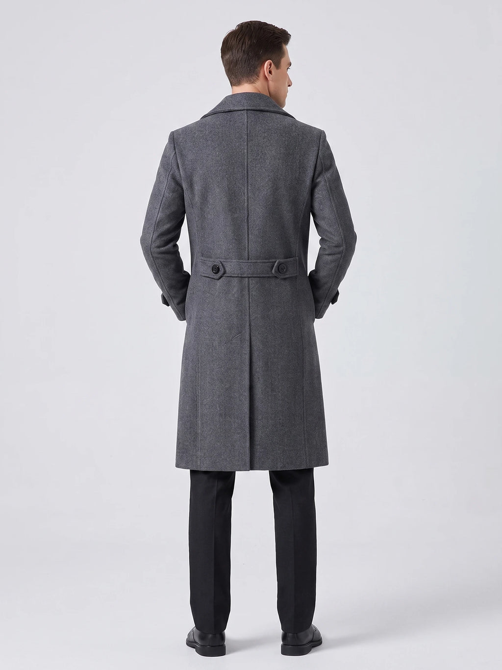 Rear studio view of a model wearing a Gray knee-length men's trench coat with a back belt, buttons, and center vent.