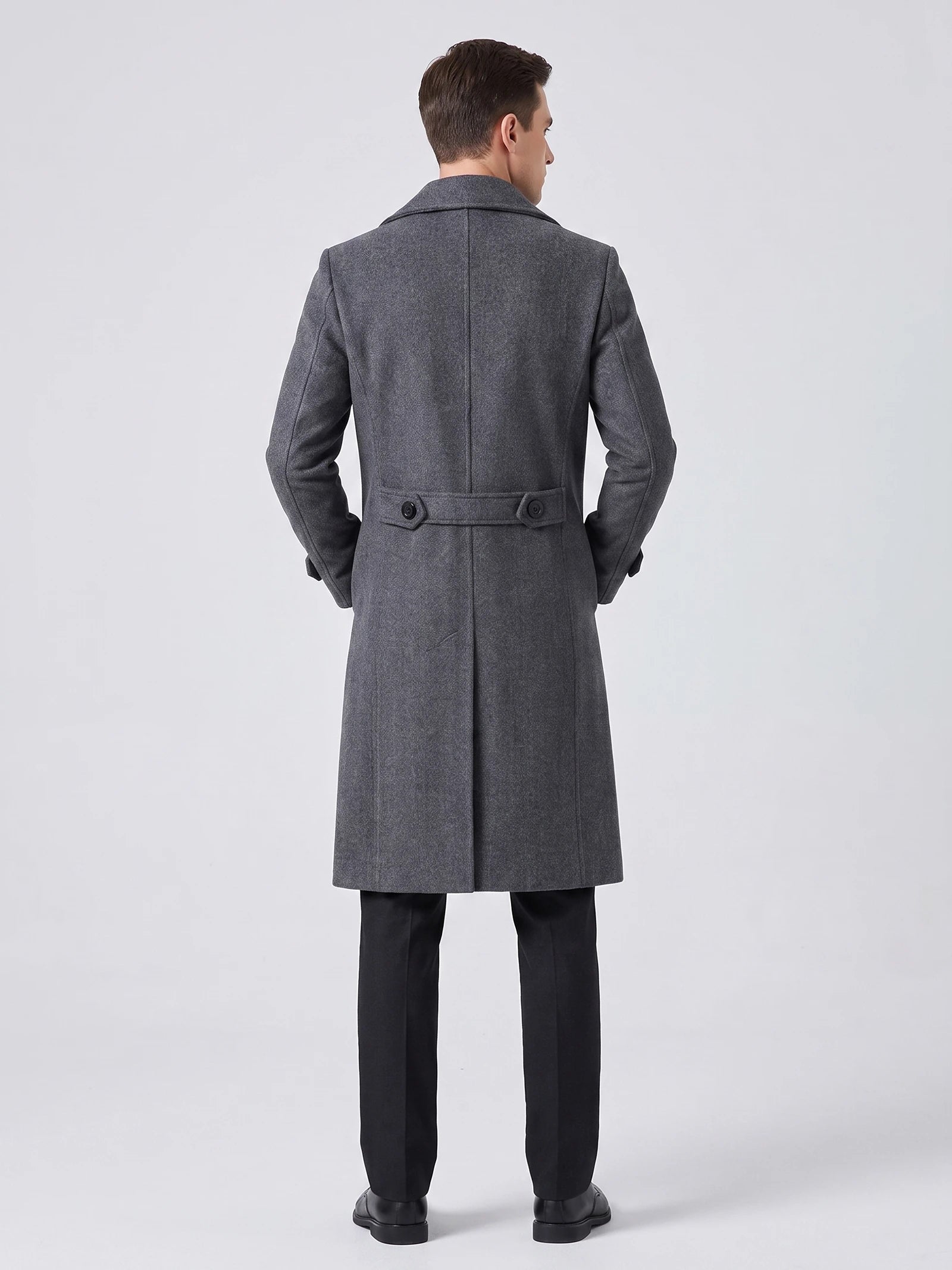 Rear studio view of a model wearing a Gray knee-length men's trench coat with a back belt, buttons, and center vent.