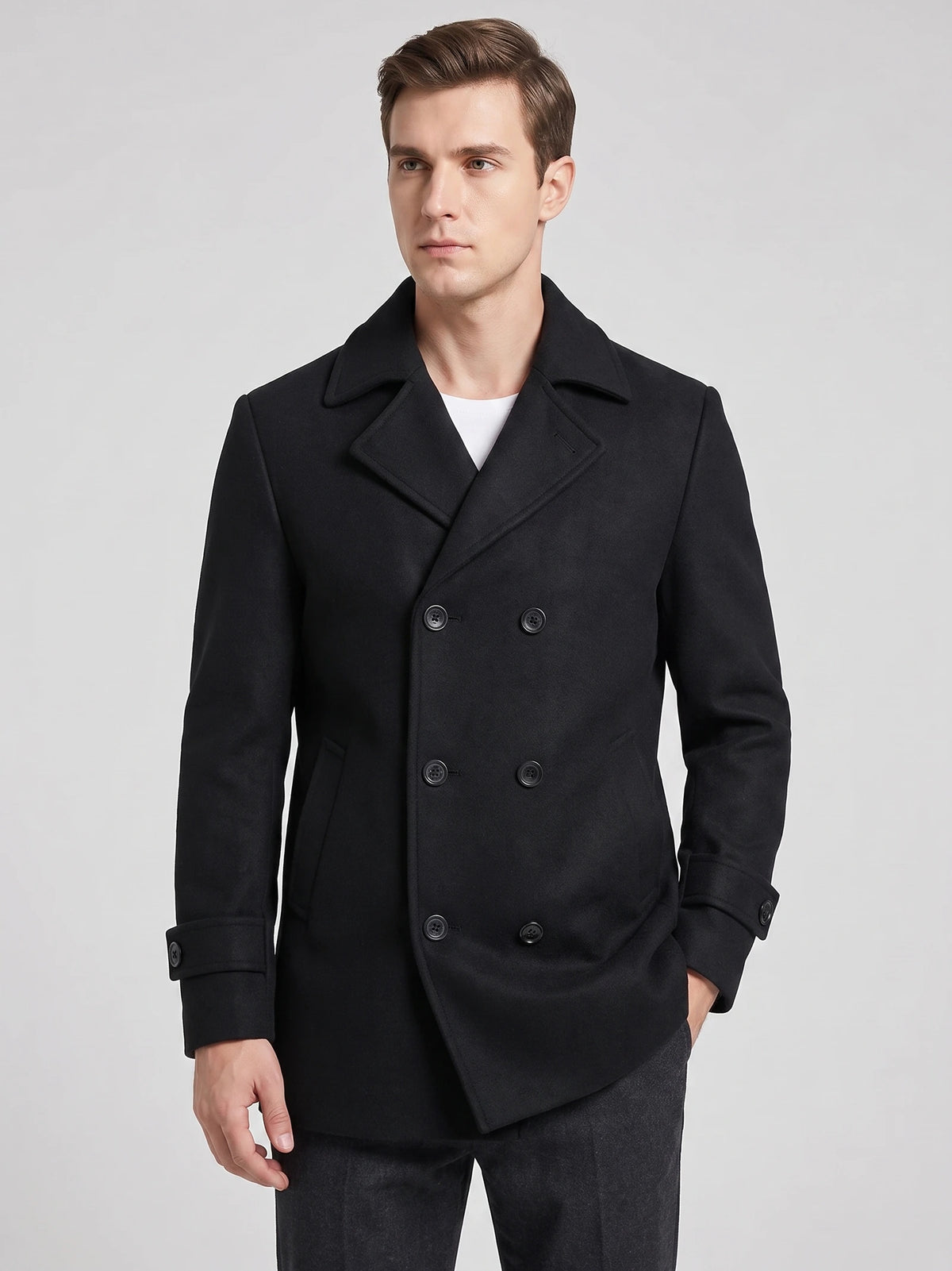 Front studio view of a model wearing a Black wool double-breasted Peacoat with wide lapels and cuff tabs.