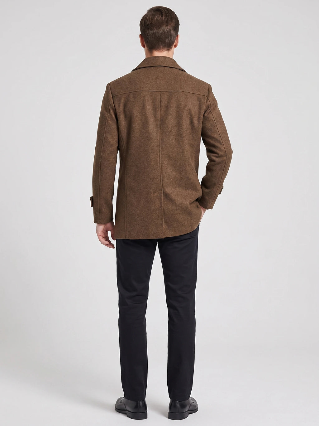 Rear studio view of a model wearing a Brown wool Peacoat with a back yoke and center seam.