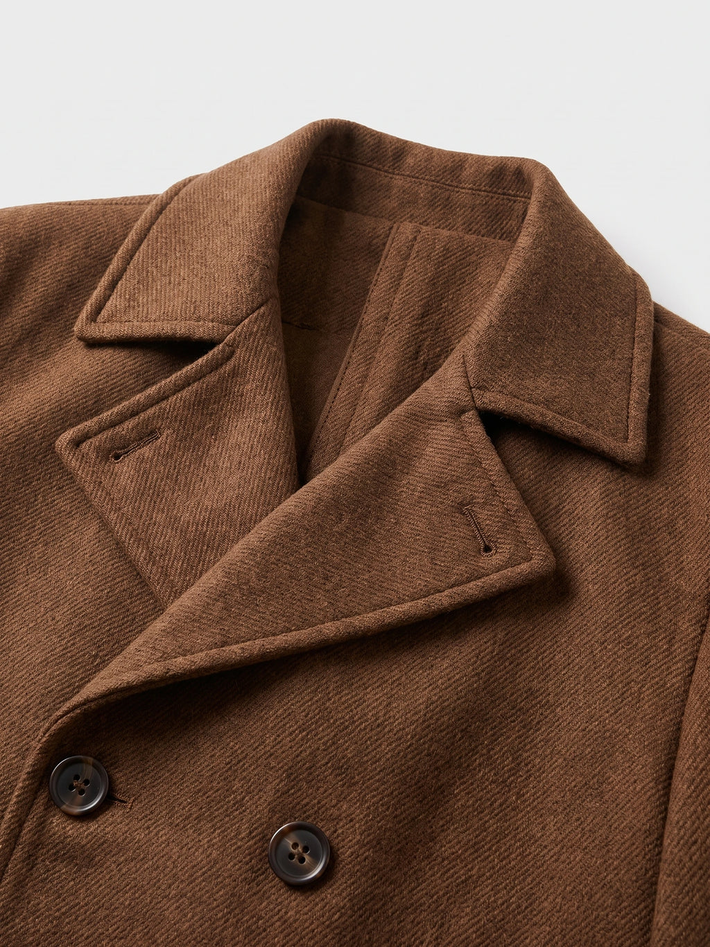 Close-up of the Brown wool Peacoat showing the wide notched collar, diagonal fabric texture, and double-breasted buttons.