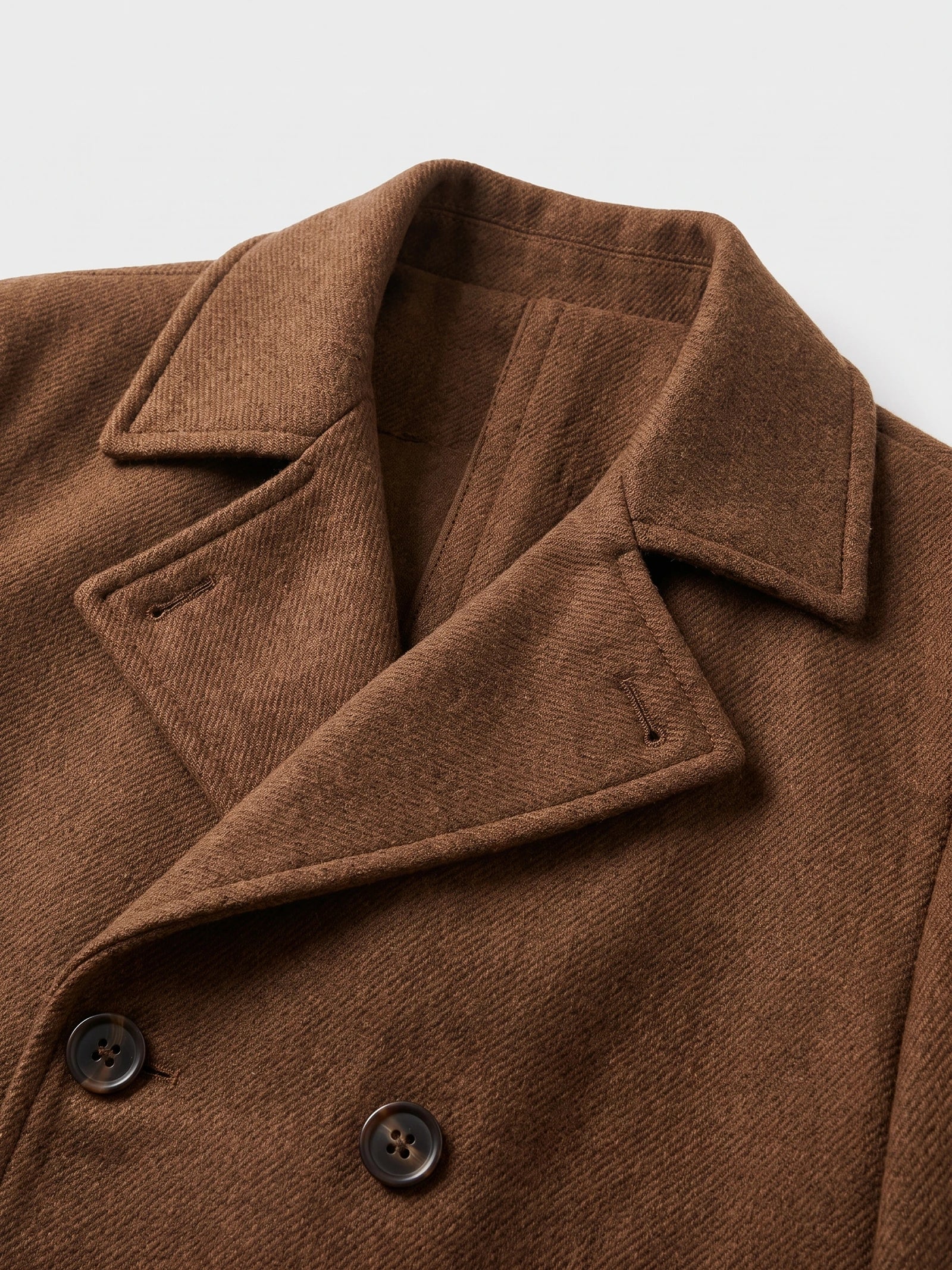 Close-up of the Brown wool Peacoat showing the wide notched collar, diagonal fabric texture, and double-breasted buttons.