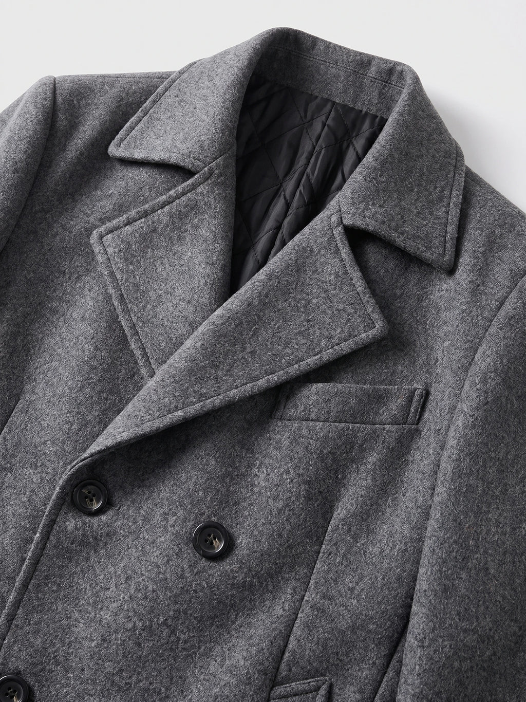 Close-up of the Gray wool Peacoat with wide lapels, double-breasted buttons, and quilted lining.