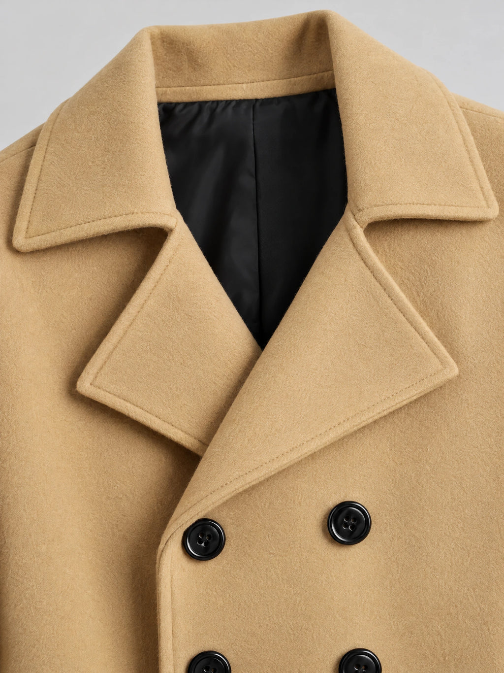 Khaki double-breasted woolen coat detail showing the wide notched collar, smooth lining, and buttoned front.