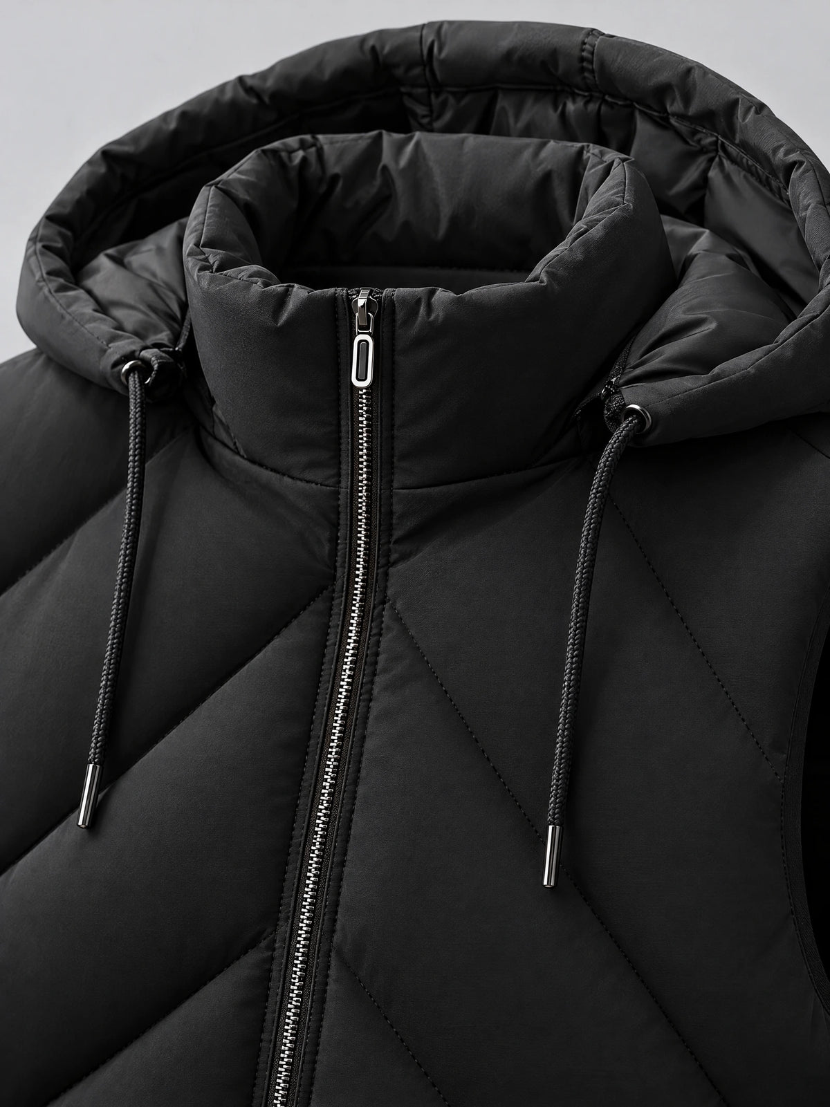 Black men’s Down Vest close-up showing the padded hood, drawcords, and front zipper.