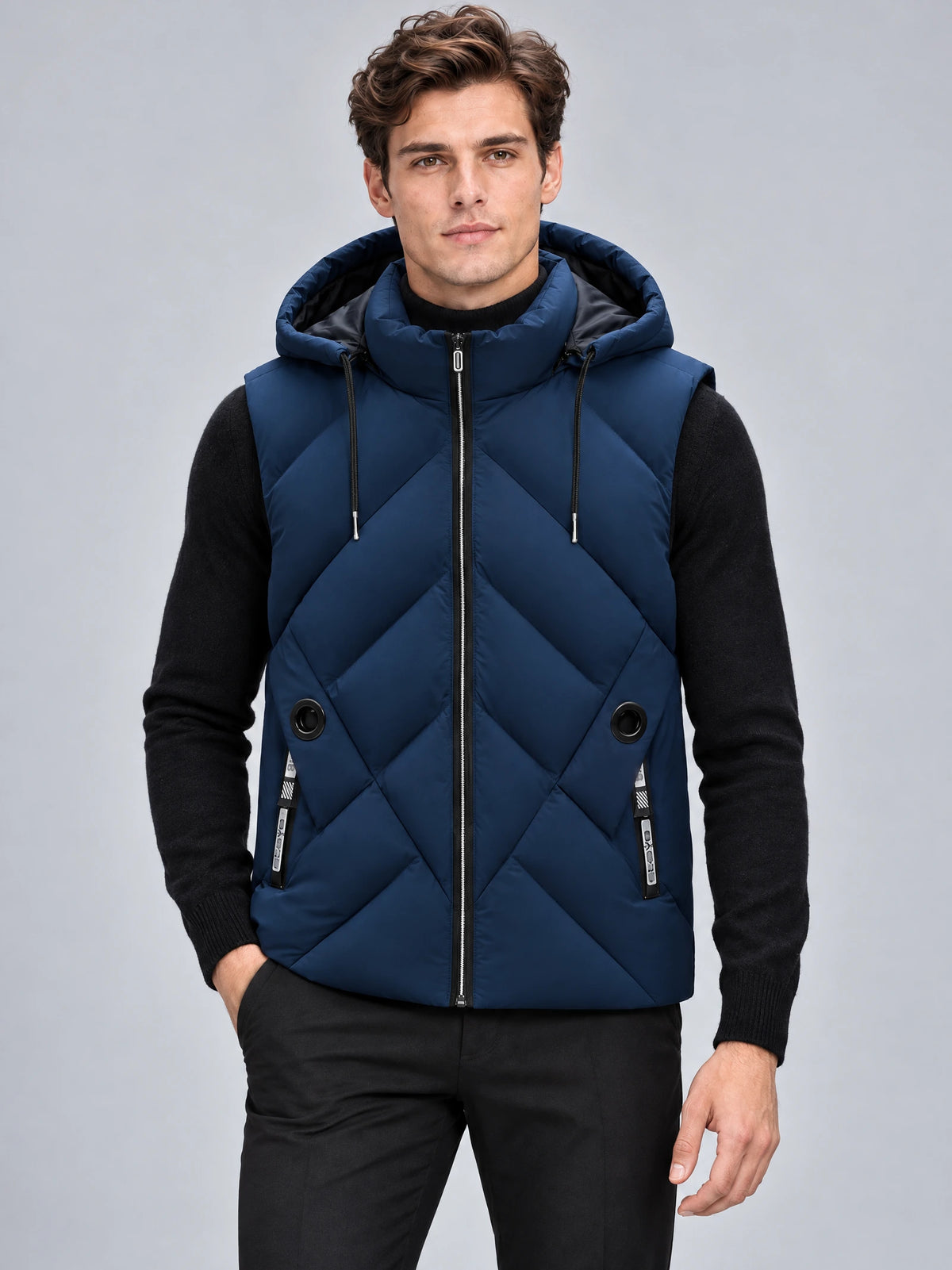 Model wearing a Navy down vest with a hood, front zipper, diagonal quilting, and zip pockets in a studio view.