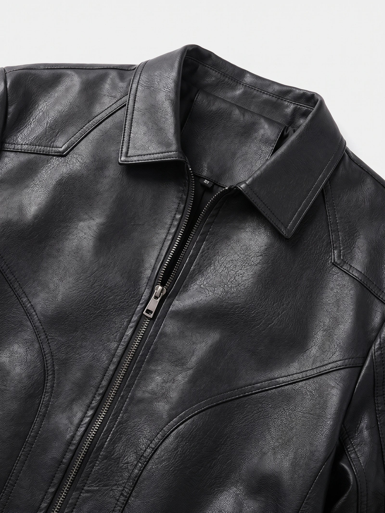 Close-up of the Black men's Fall Jacket showing its textured PU leather, pointed collar, front zipper, and stitched chest panels.