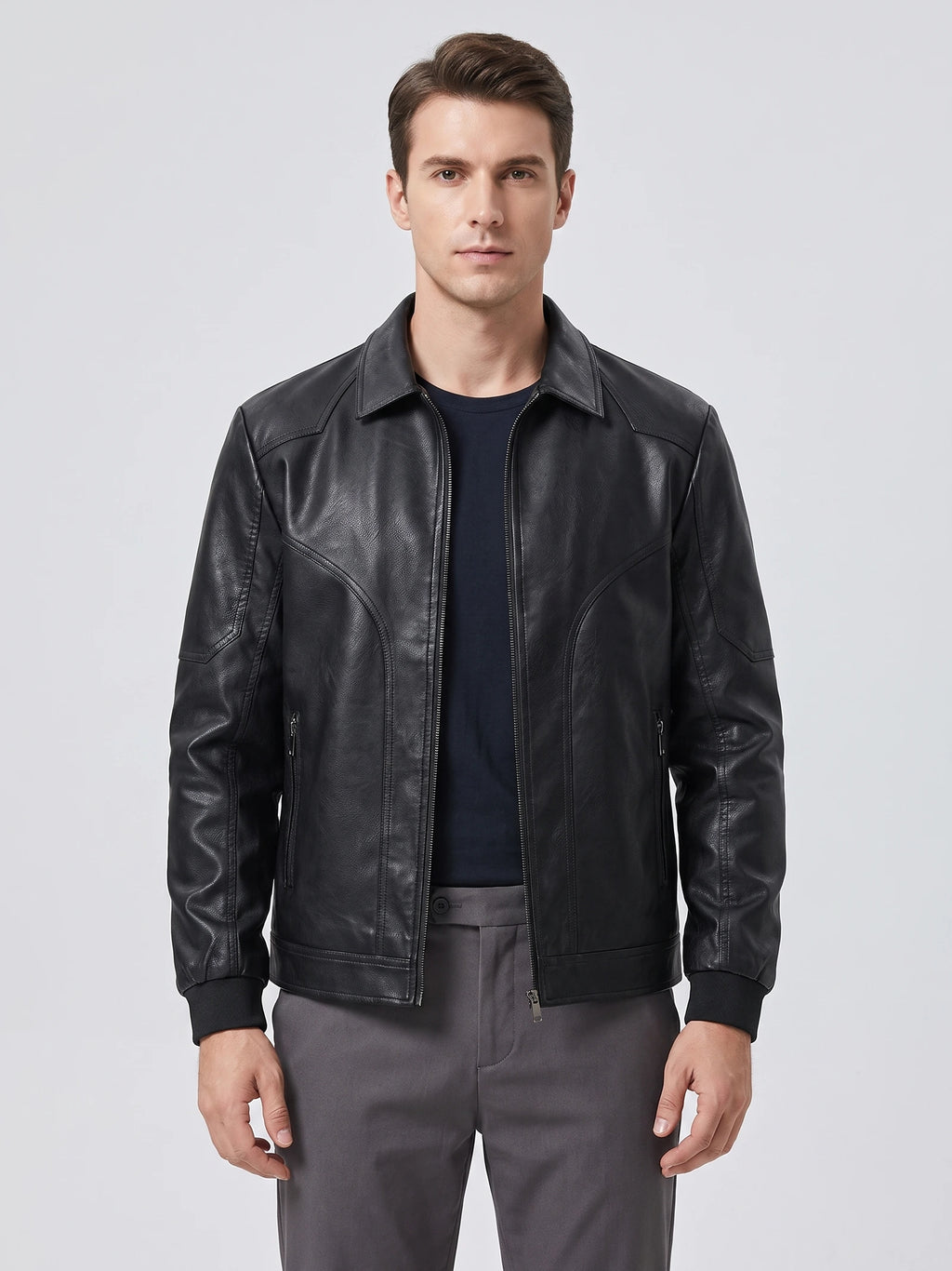 Front studio view of a model wearing a Black PU leather Fall Jacket with a zip front, pointed collar, and zippered pockets.