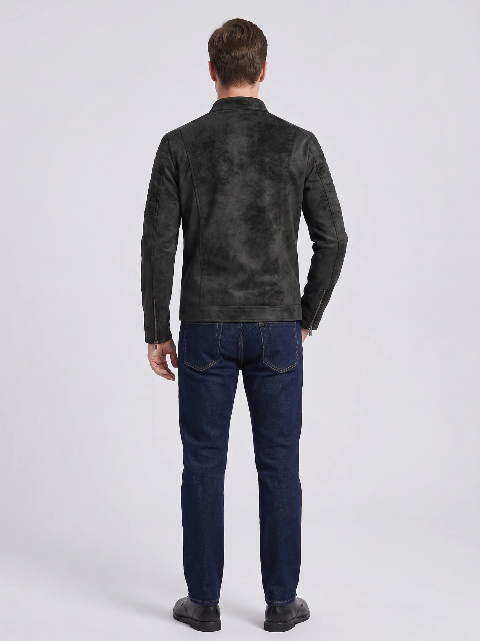 Rear studio view of a model wearing a Black faux leather Fall Jacket with quilted shoulder panels and zip cuffs.