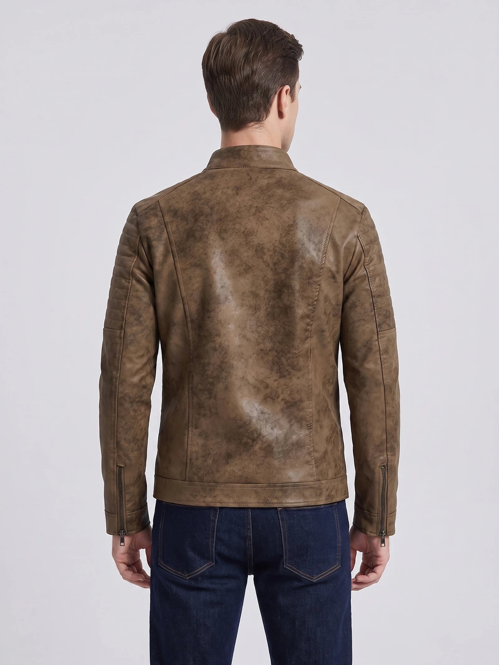 Rear studio view of a model wearing a Brown faux leather Fall Jacket with quilted shoulder panels and zip cuffs.