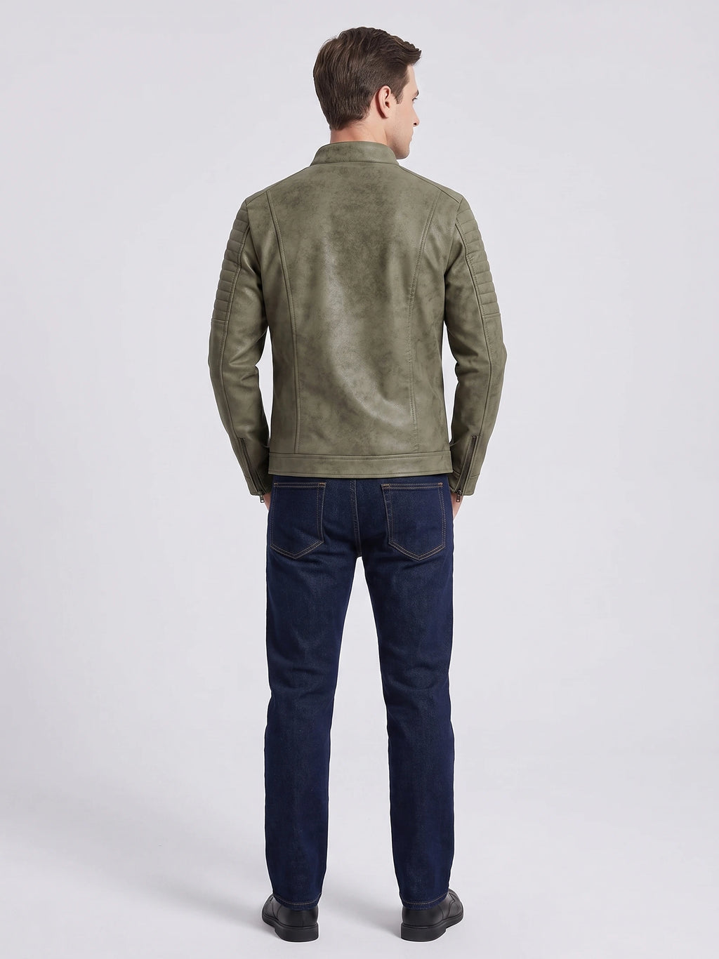 Rear studio view of a model wearing a Green faux leather Fall Jacket with quilted shoulder panels and zip cuffs.
