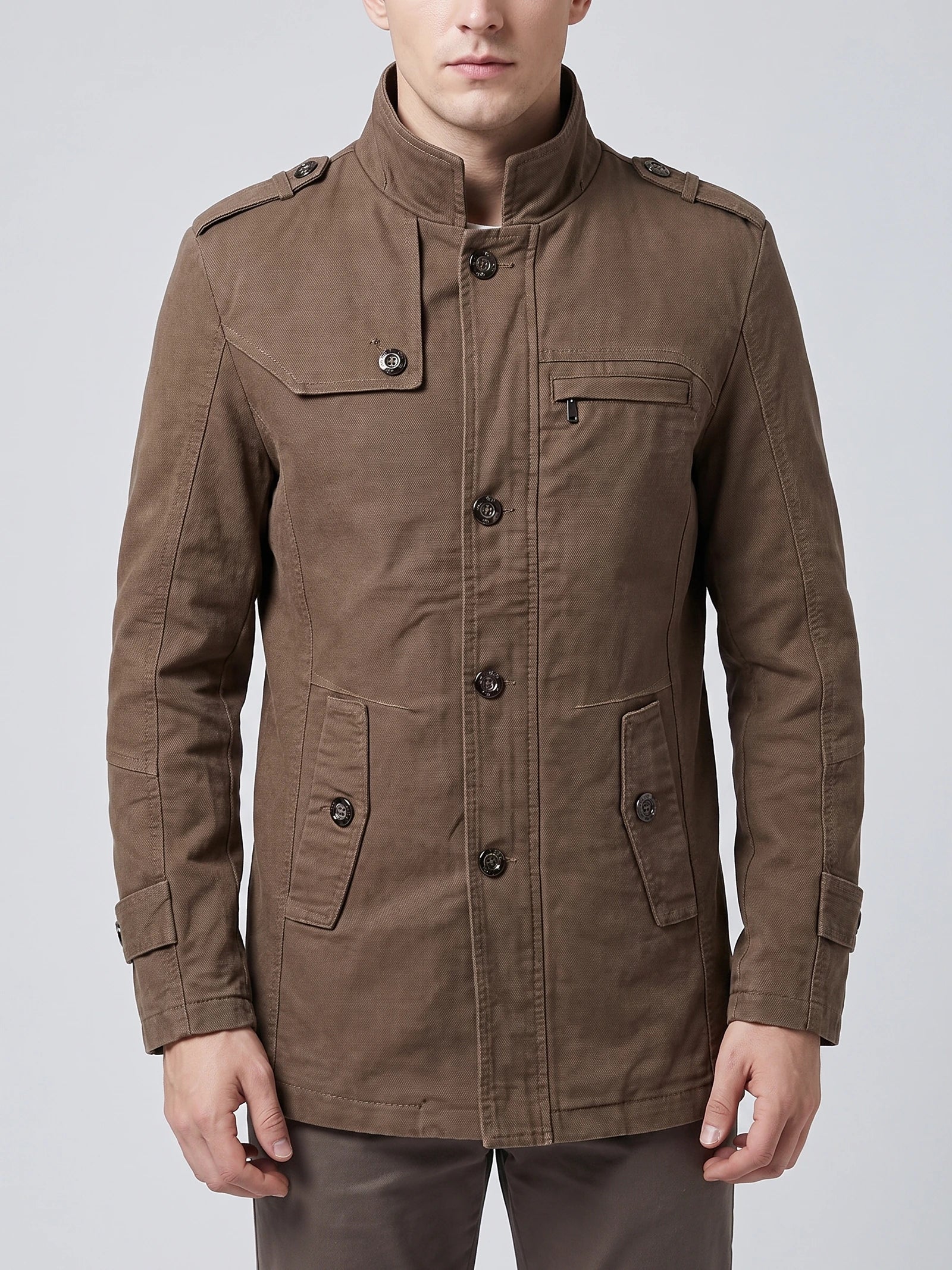 Front studio view of a model wearing a Brown cotton Fall Trench Coat with a stand collar, button closure, shoulder tabs, and multiple pockets.