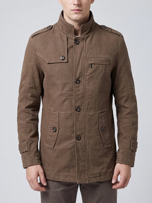 Front studio view of a model wearing a Brown cotton Fall Trench Coat with a stand collar, button closure, shoulder tabs, and multiple pockets.