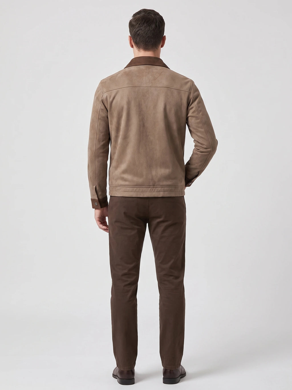 Rear studio view of a model wearing a Brown faux Suede Jacket with a back yoke seam and buttoned cuffs.