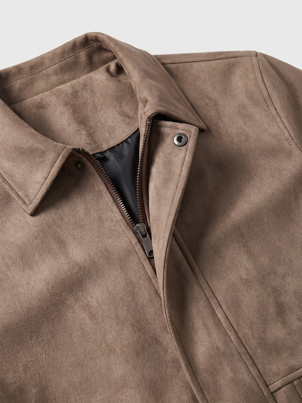 Close-up of a Brown faux suede jacket with a lapel collar, front zipper, snap tab, and visible lining.