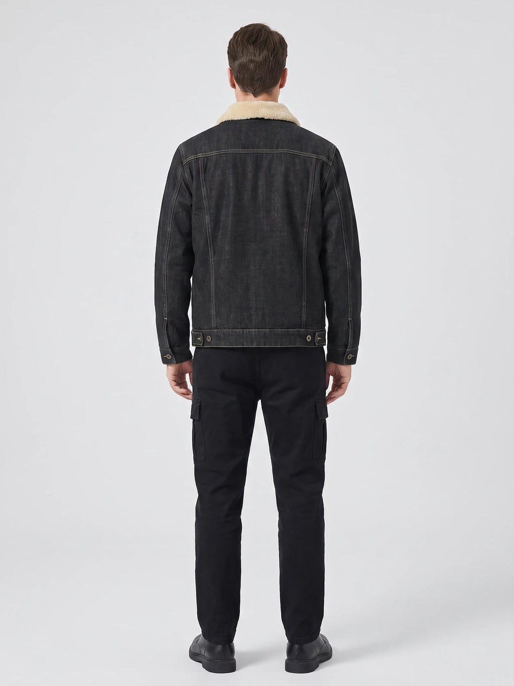 Rear studio view of a model wearing a Black fleece jacket with a shearling-style collar, stitched back panels, and button-adjustable hem.