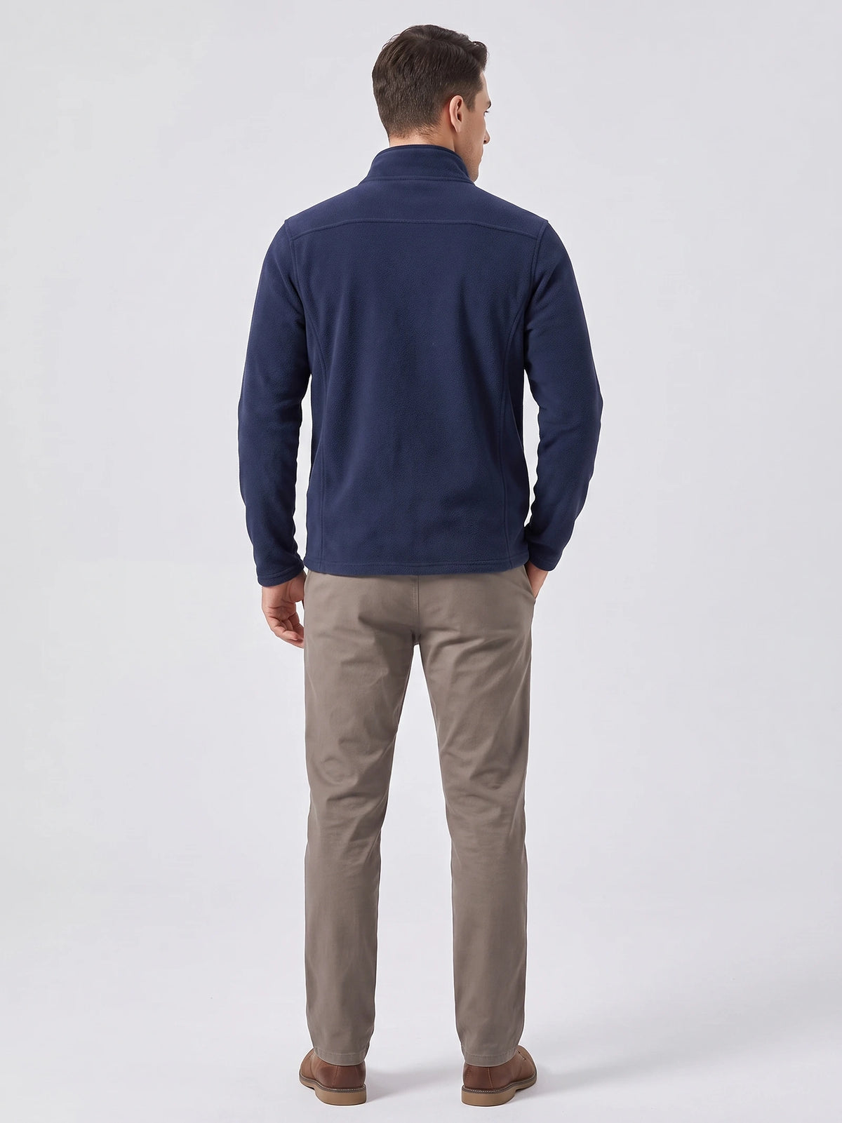 Rear studio view of a model wearing a Navy men's Fleece Jacket with a stand collar and back yoke seam.
