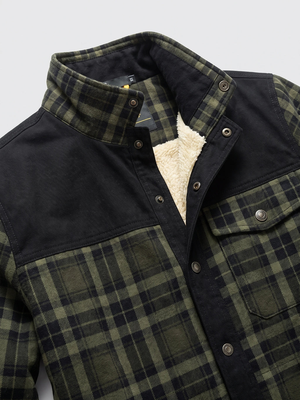 Green plaid shirt jacket detail showing the snap-front collar, chest pockets, and fleece lining.