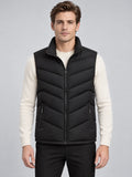 Front studio view of a model wearing a Black fleece lined puffer vest with a stand collar, zip front, chevron quilting, and zip pockets.