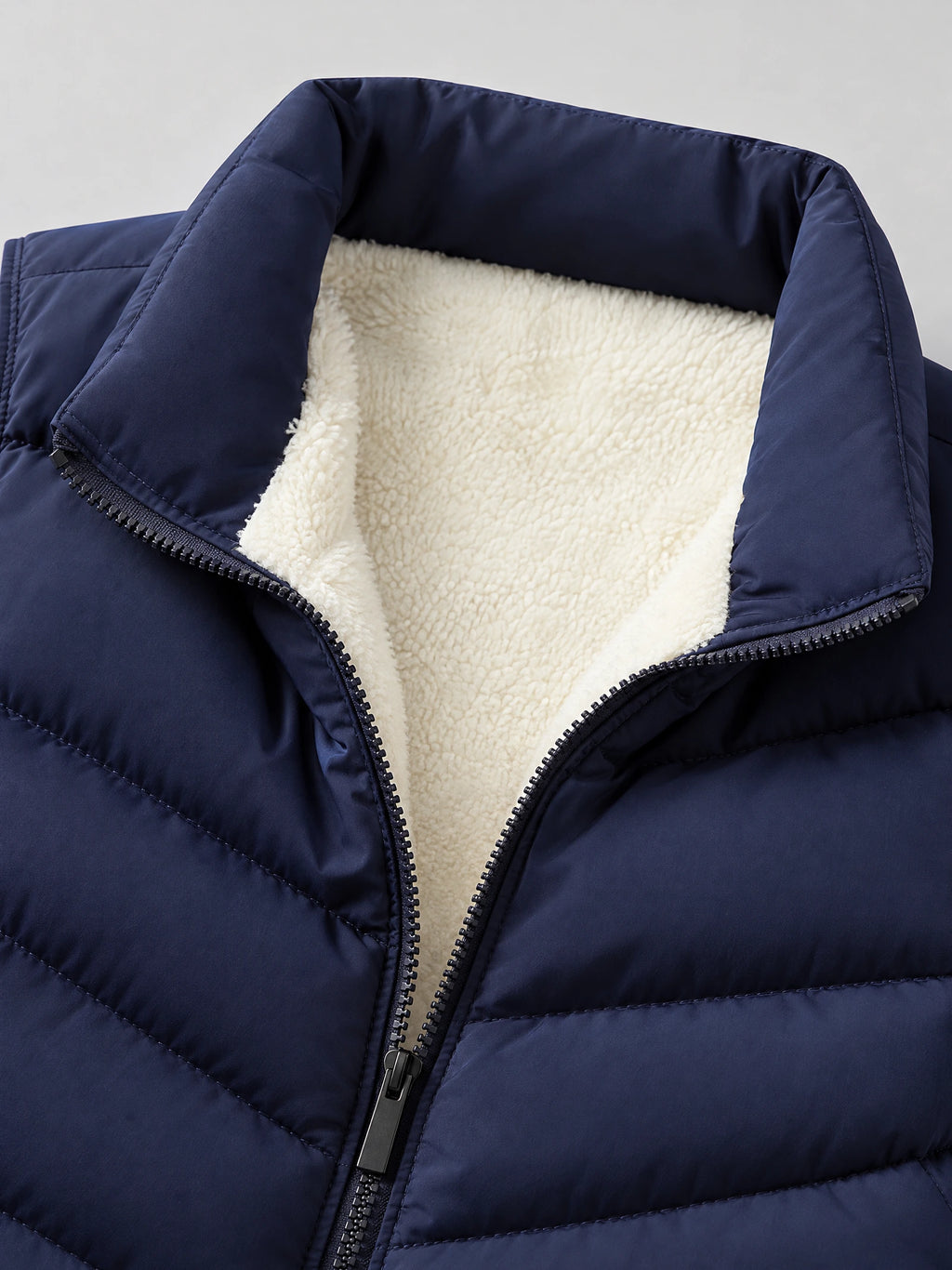 Close-up of the Navy Fleece Lined Puffer Vest showing the stand collar, soft fleece lining, and front zipper.