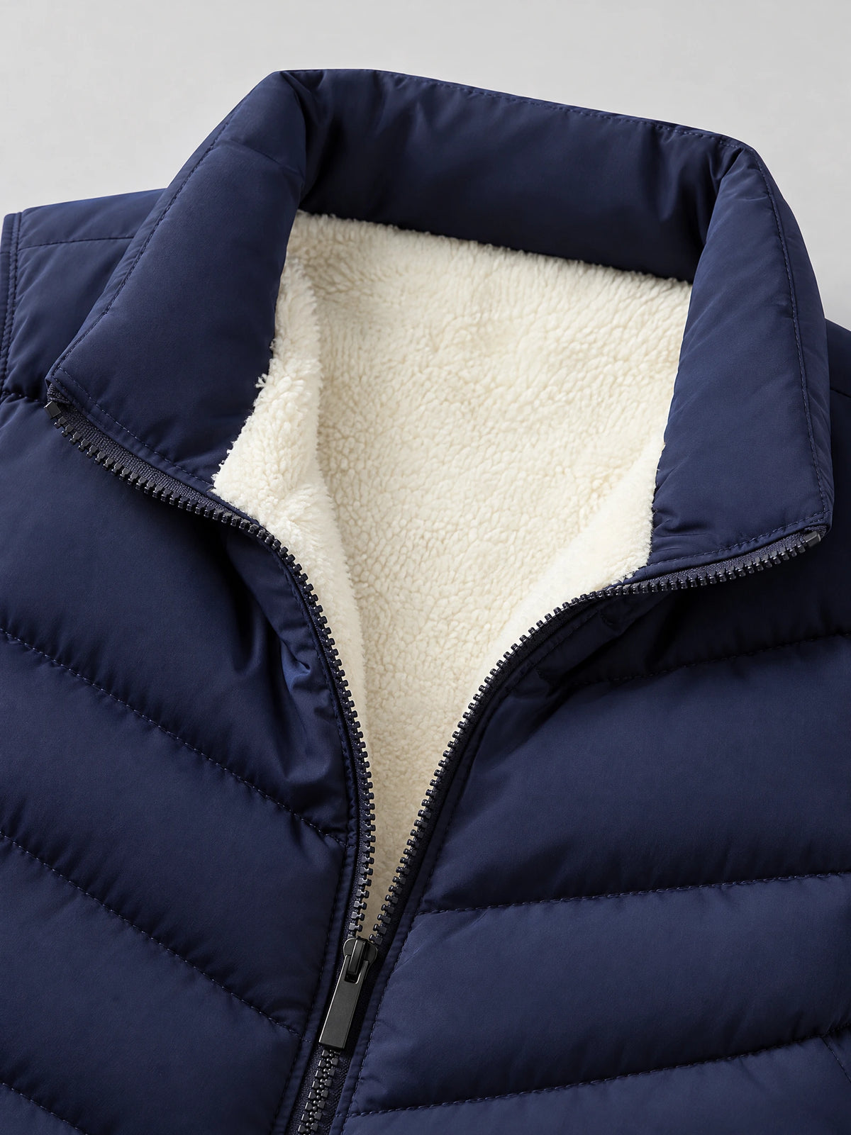 Close-up of the Navy Fleece Lined Puffer Vest showing the stand collar, soft fleece lining, and front zipper.