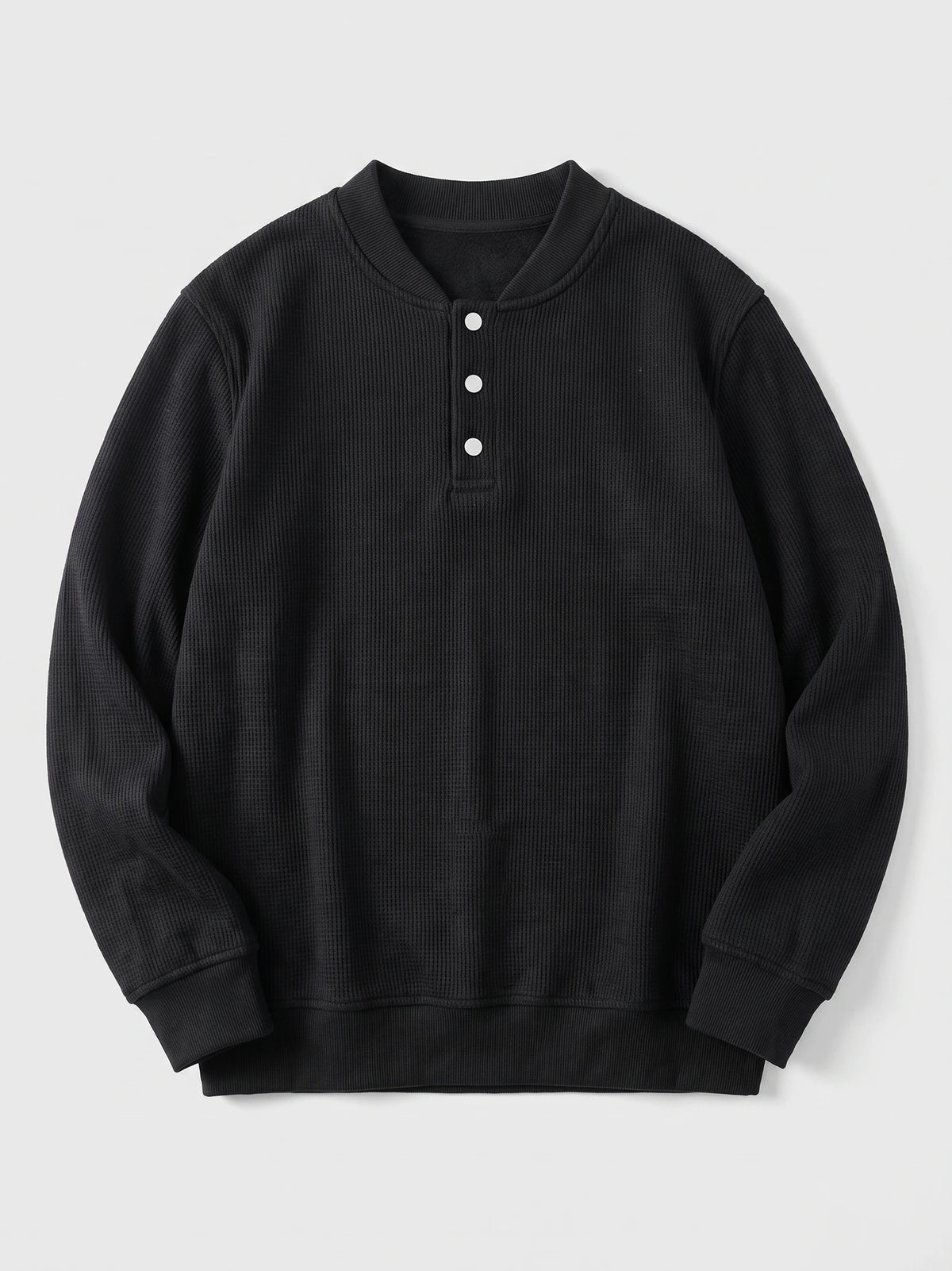 Black fleece lined sweater laid flat, featuring a ribbed shawl collar, three-button placket, and long sleeves.