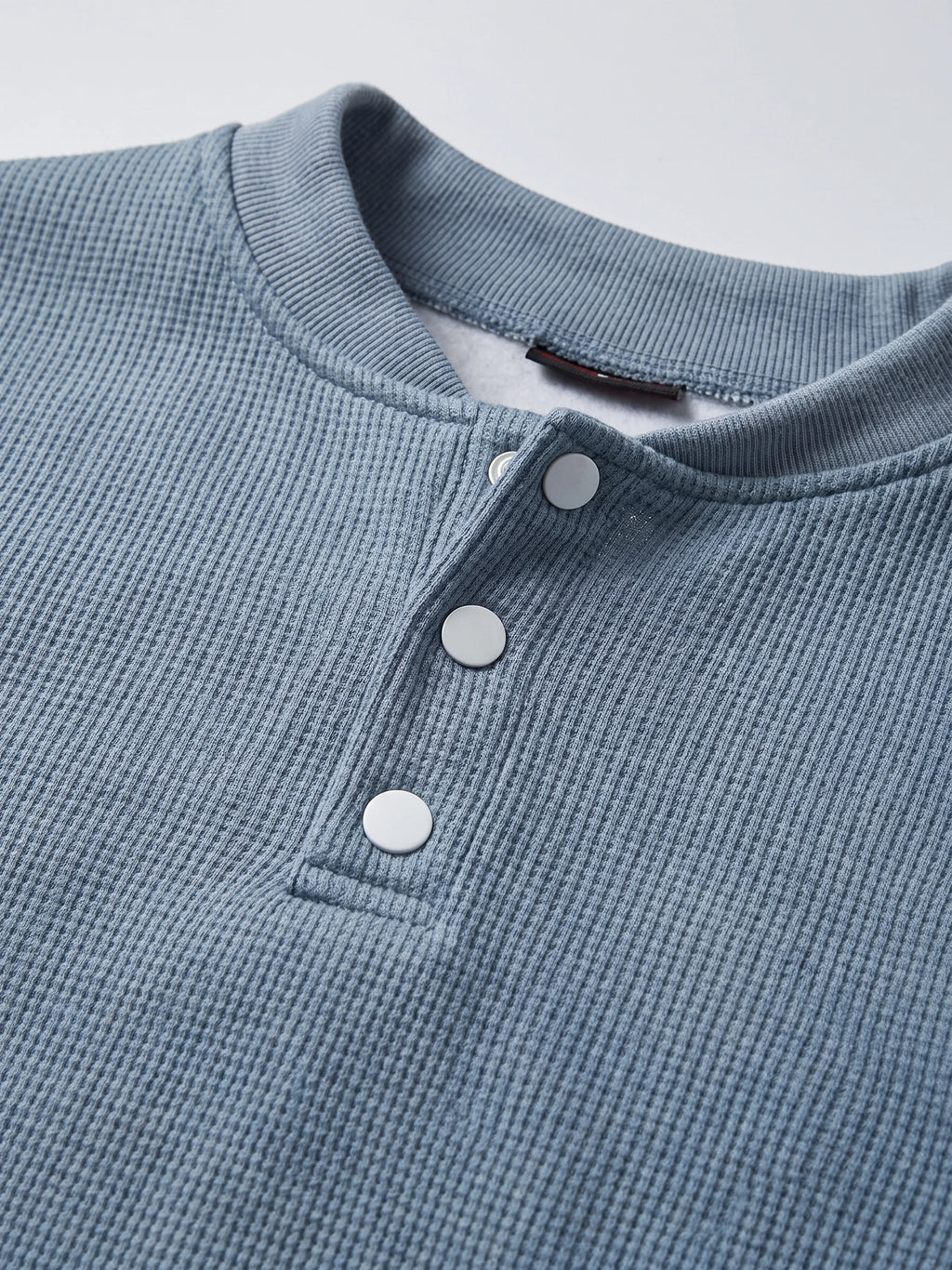 Close-up of the Blue men's Fleece Lined Sweater with a ribbed knit texture, crew neckline, and three-button Henley placket.
