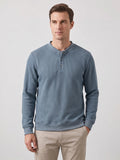 Front studio view of a model wearing a Blue fleece lined sweater with a ribbed knit texture and three-button Henley placket.