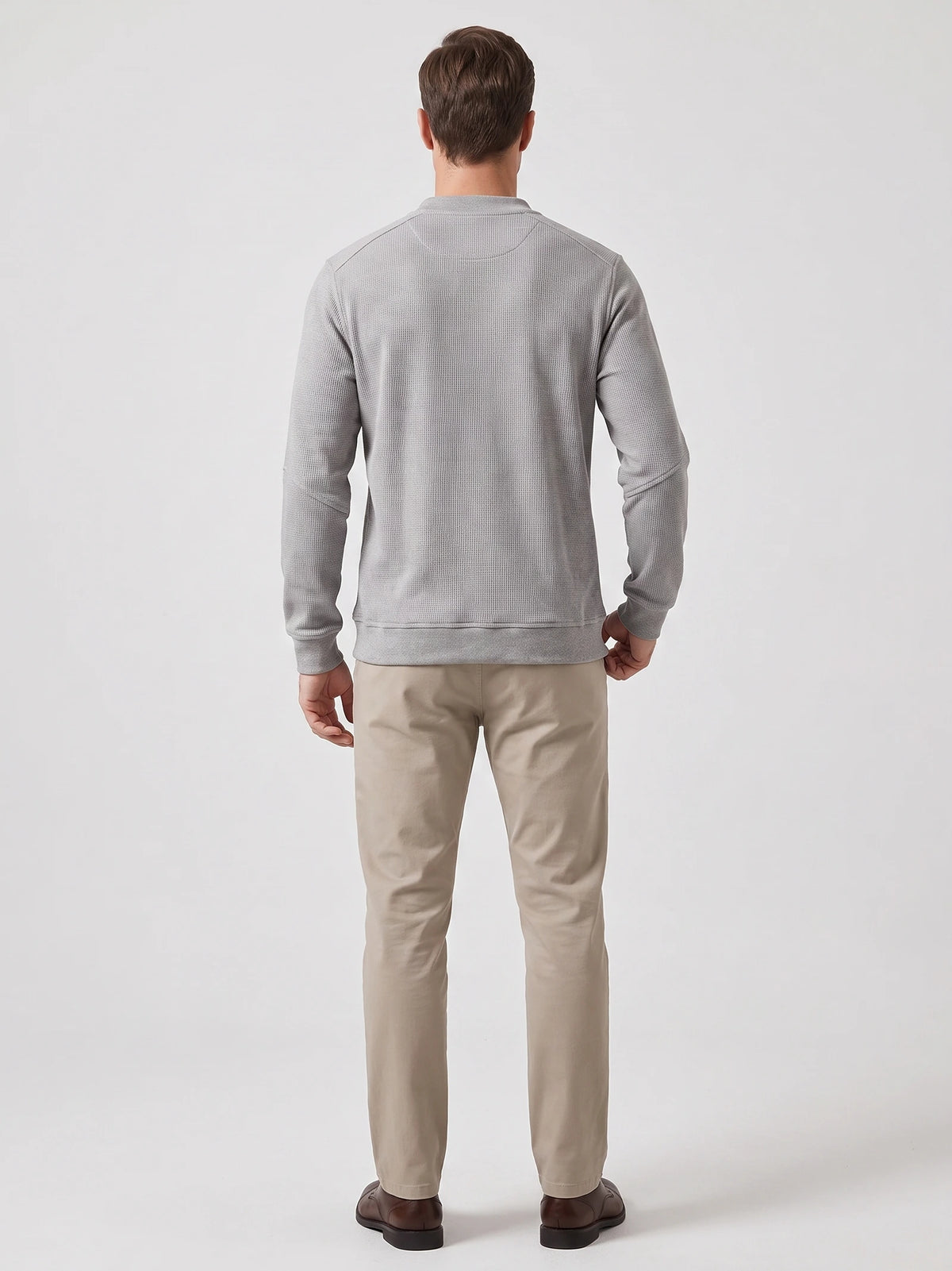 Rear studio view of a model wearing a Gray Fleece Lined Sweater with long sleeves, ribbed cuffs, and hem.