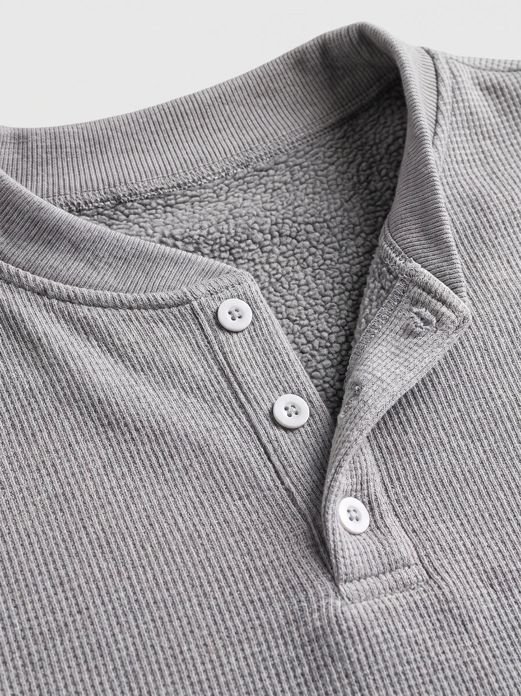 Close-up of the Gray fleece lined sweater’s ribbed Henley neckline, button placket, and soft fleece interior.
