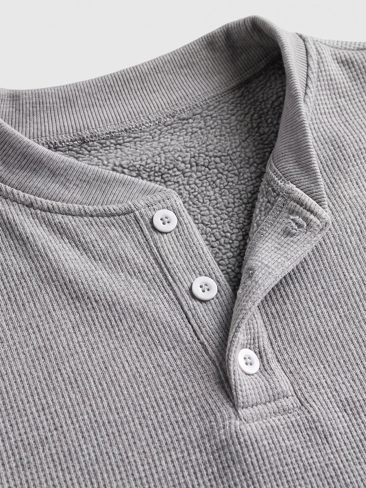 Close-up of the Gray fleece lined sweater’s ribbed Henley neckline, button placket, and soft fleece interior.