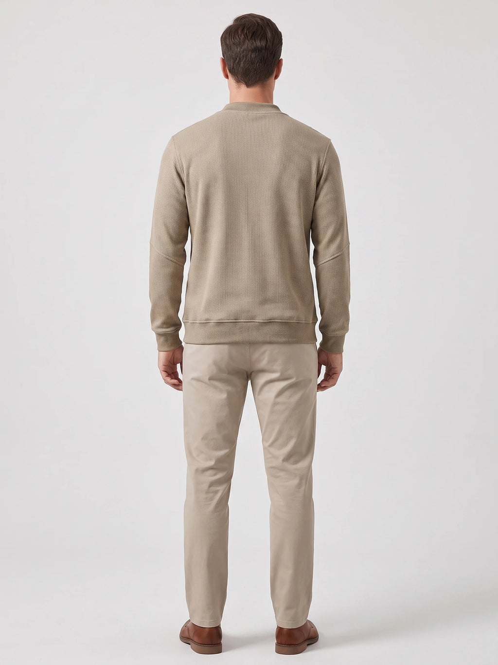 Back view of a model wearing a Khaki fleece lined sweater with long sleeves, ribbed cuffs, and hem.