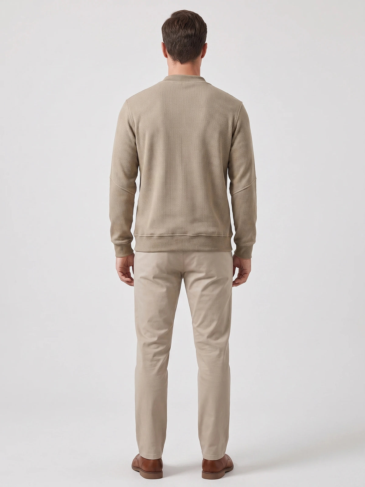 Back view of a model wearing a Khaki fleece lined sweater with long sleeves, ribbed cuffs, and hem.