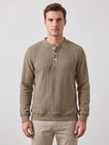 Front studio view of a model wearing a Khaki fleece lined sweater with ribbed texture, long sleeves, and a three-button Henley placket.