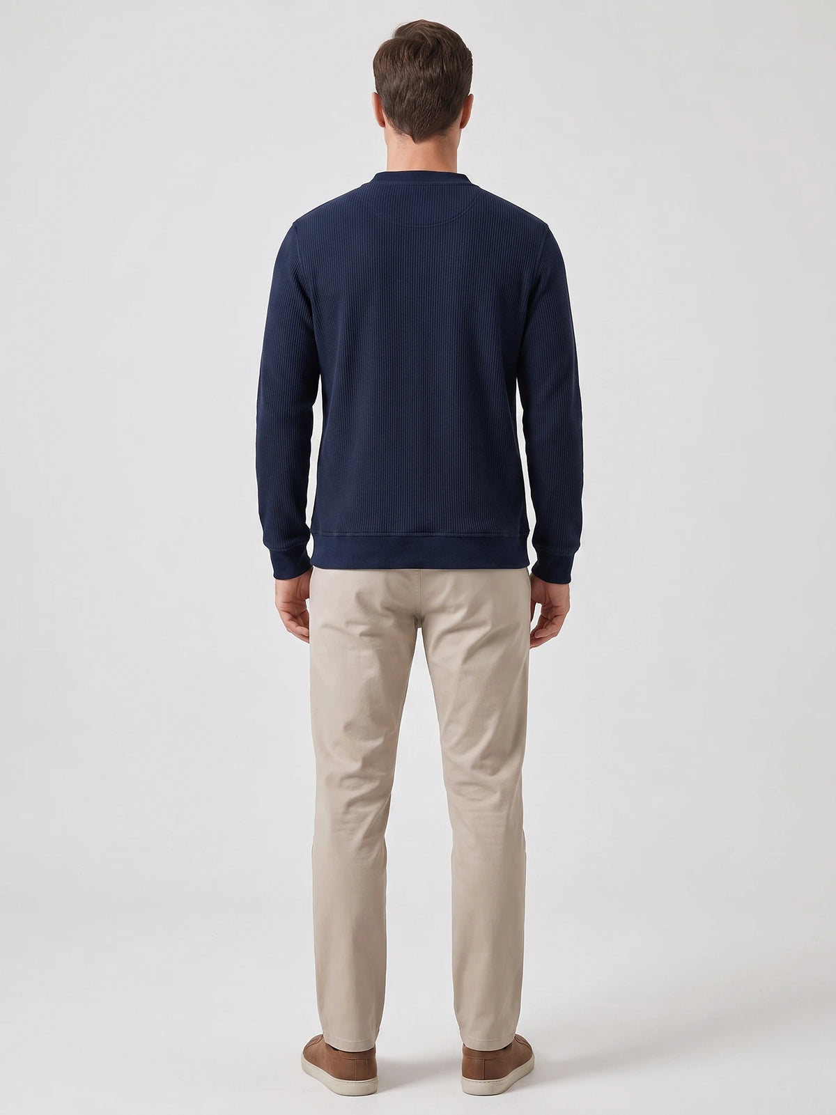 Rear studio view of a model wearing a Navy fleece lined sweater with long sleeves, ribbed cuffs, and hem.