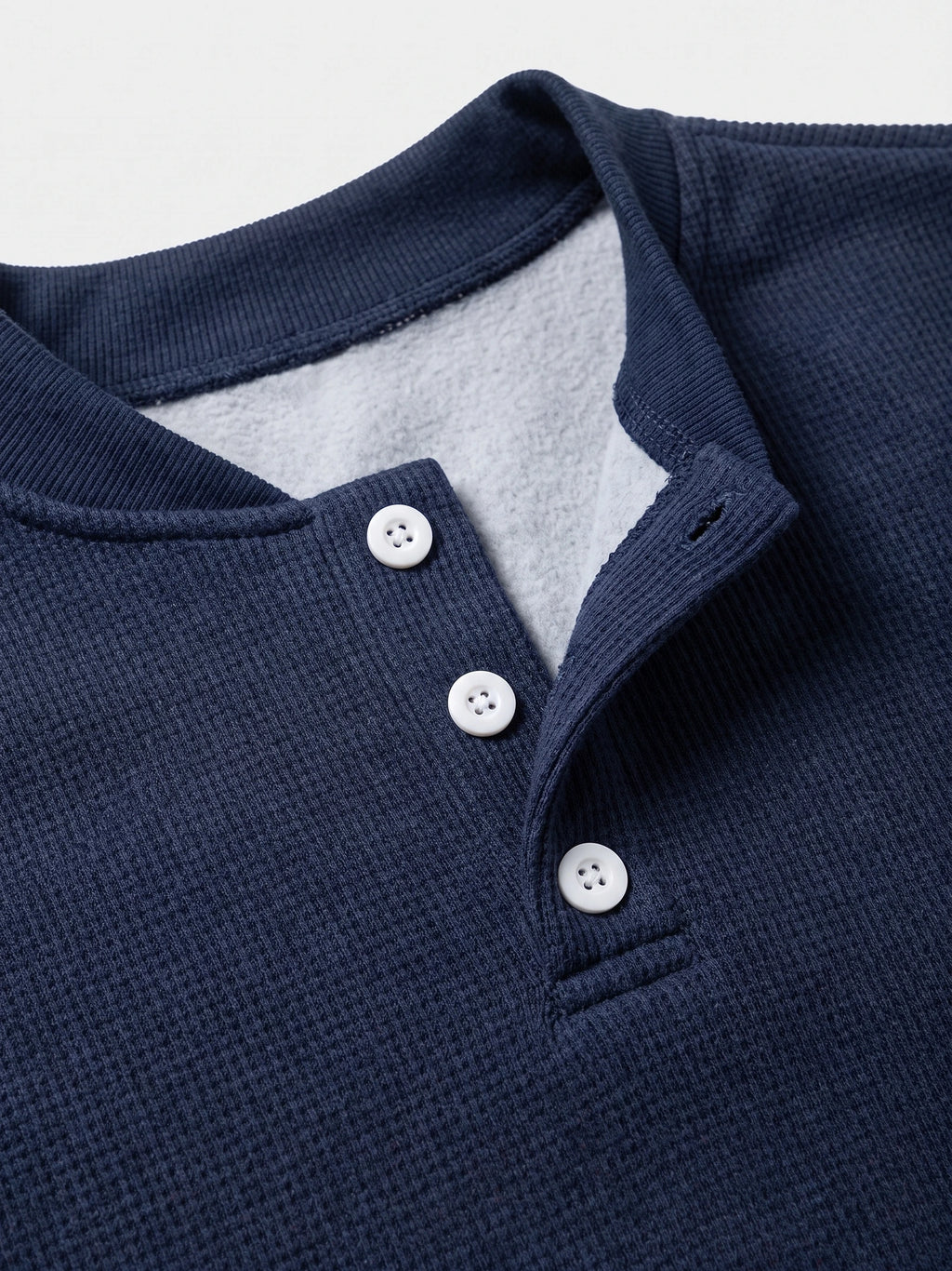 Close-up of the Navy fleece lined sweater’s ribbed collar, three-button Henley placket, and soft inner lining.