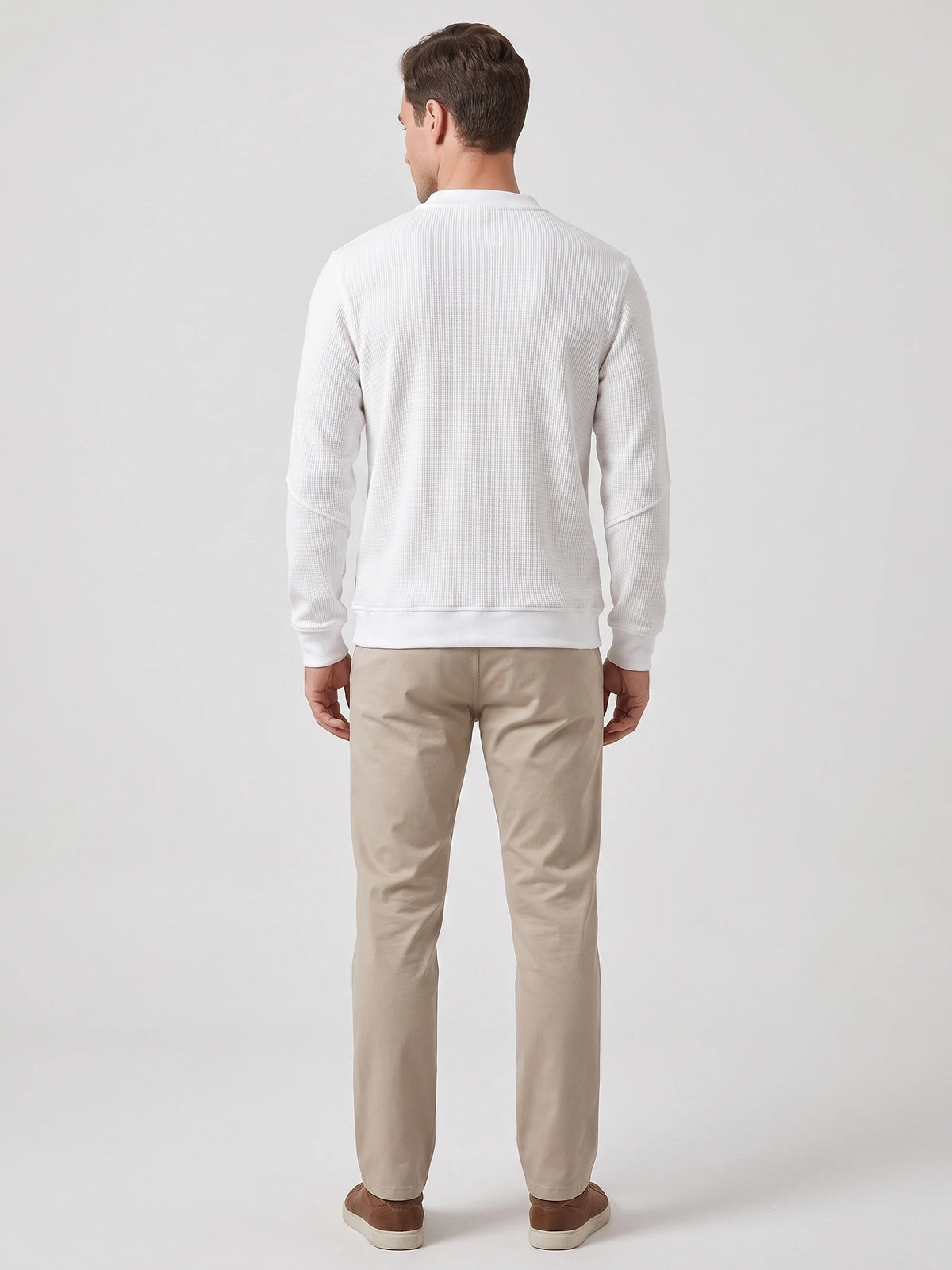 Back view of a model wearing a White fleece lined sweater with a textured knit body and ribbed cuffs and hem.