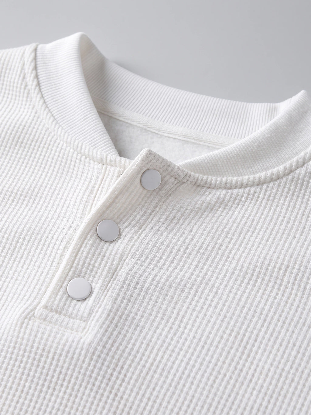 Close-up of the White fleece lined sweater’s ribbed mock neck, three-button Henley placket, and soft interior lining.