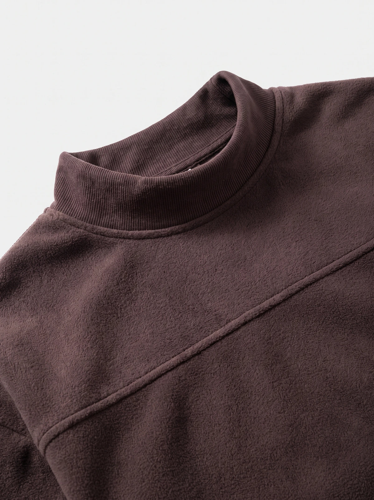 Brown fleece sweater close-up showing the ribbed mock neck, soft textured fabric, and chest pocket trim.