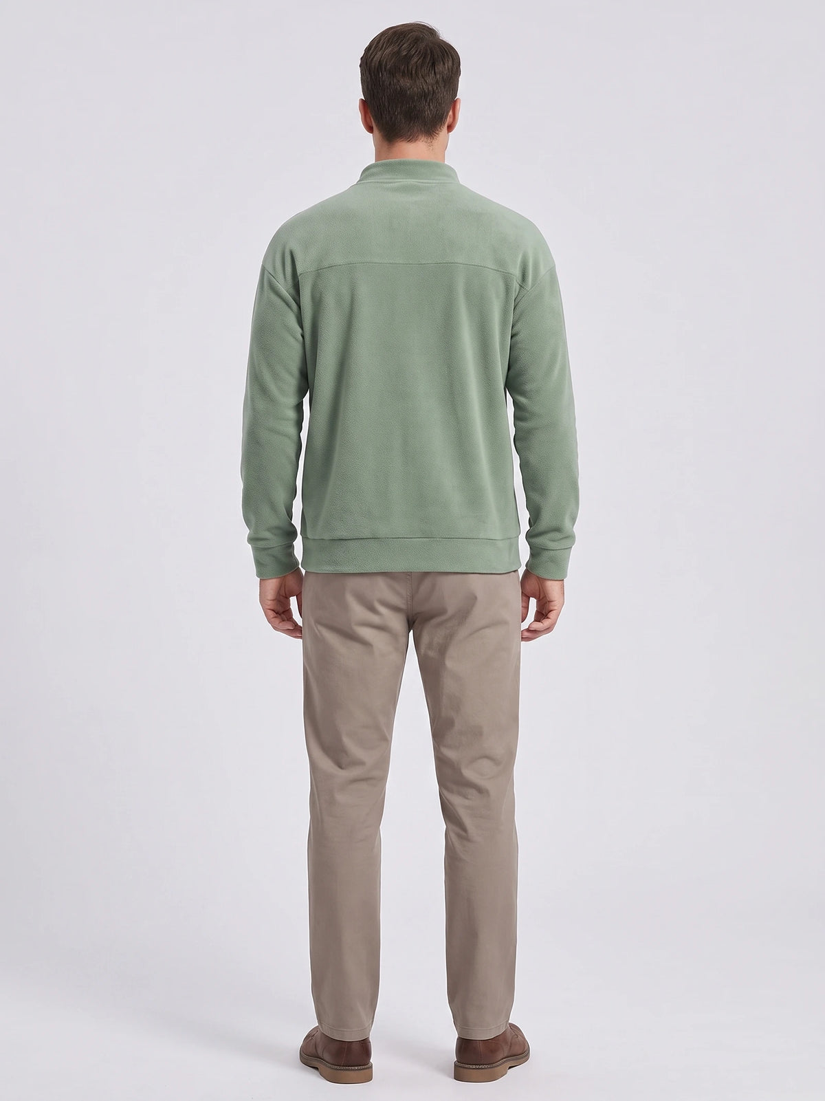 Back view of a model wearing a Green men's Fleece Sweater with a mock neck, long sleeves, and ribbed cuffs and hem.