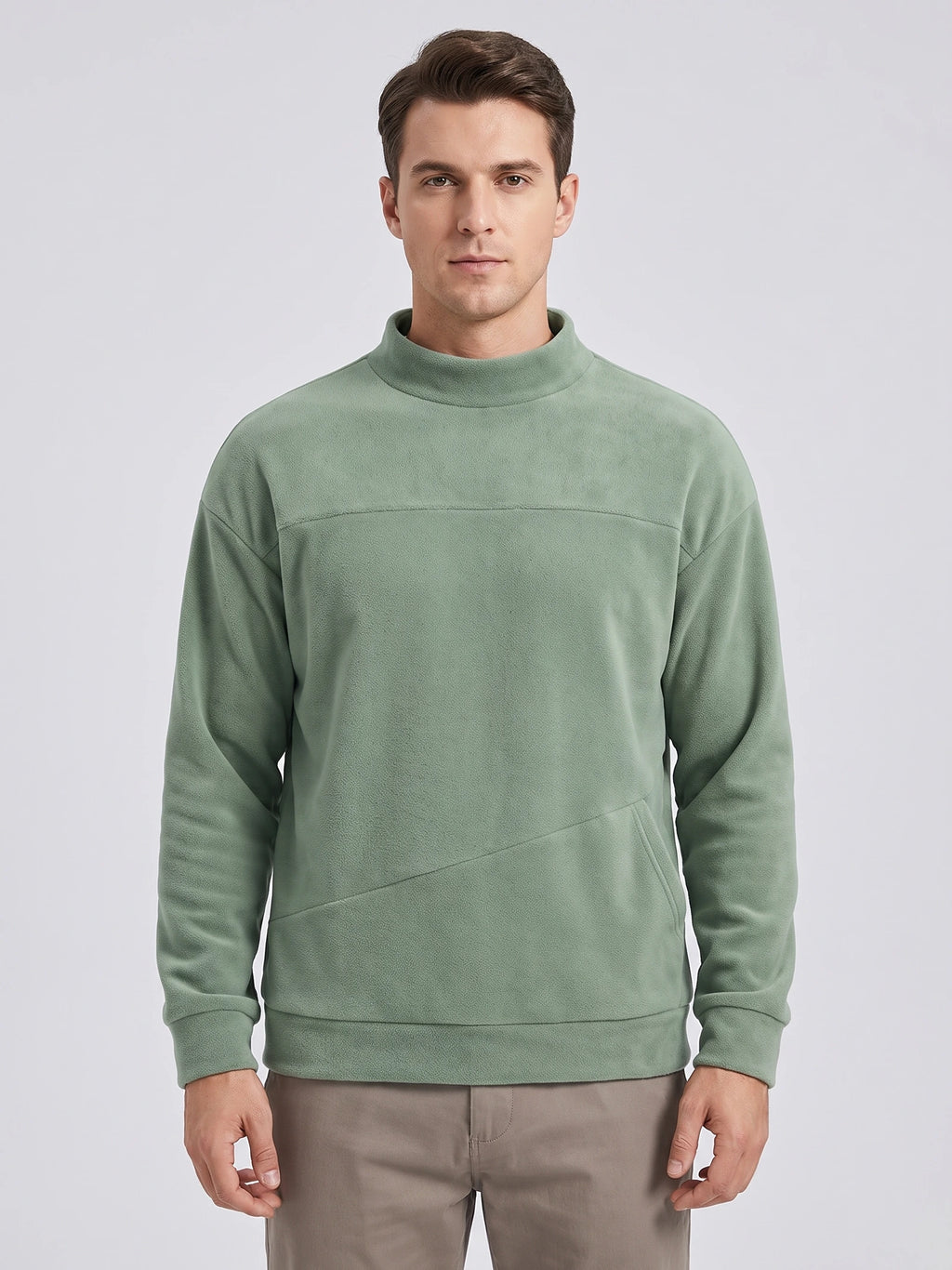 Front studio view of a model wearing a Green men's Fleece Sweater with a mock neck and angled kangaroo pocket.