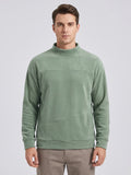 Front studio view of a model wearing a Green men's Fleece Sweater with a mock neck and angled kangaroo pocket.