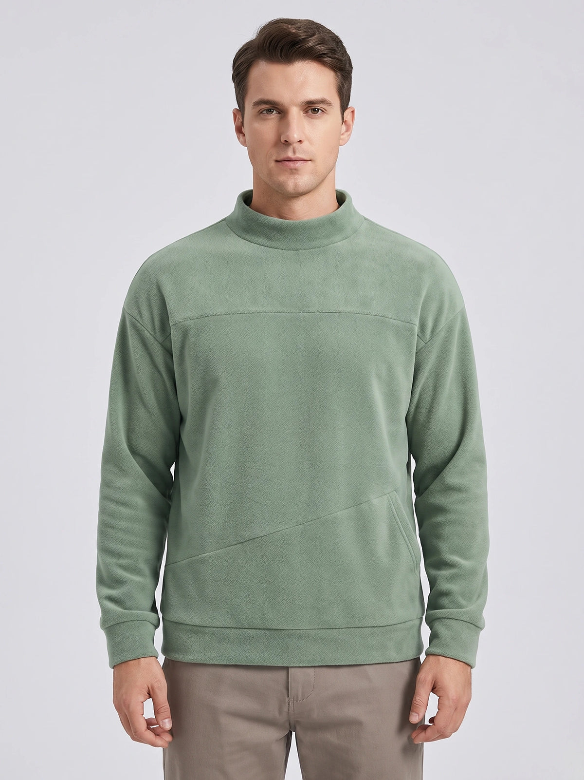 Front studio view of a model wearing a Green men's Fleece Sweater with a mock neck and angled kangaroo pocket.