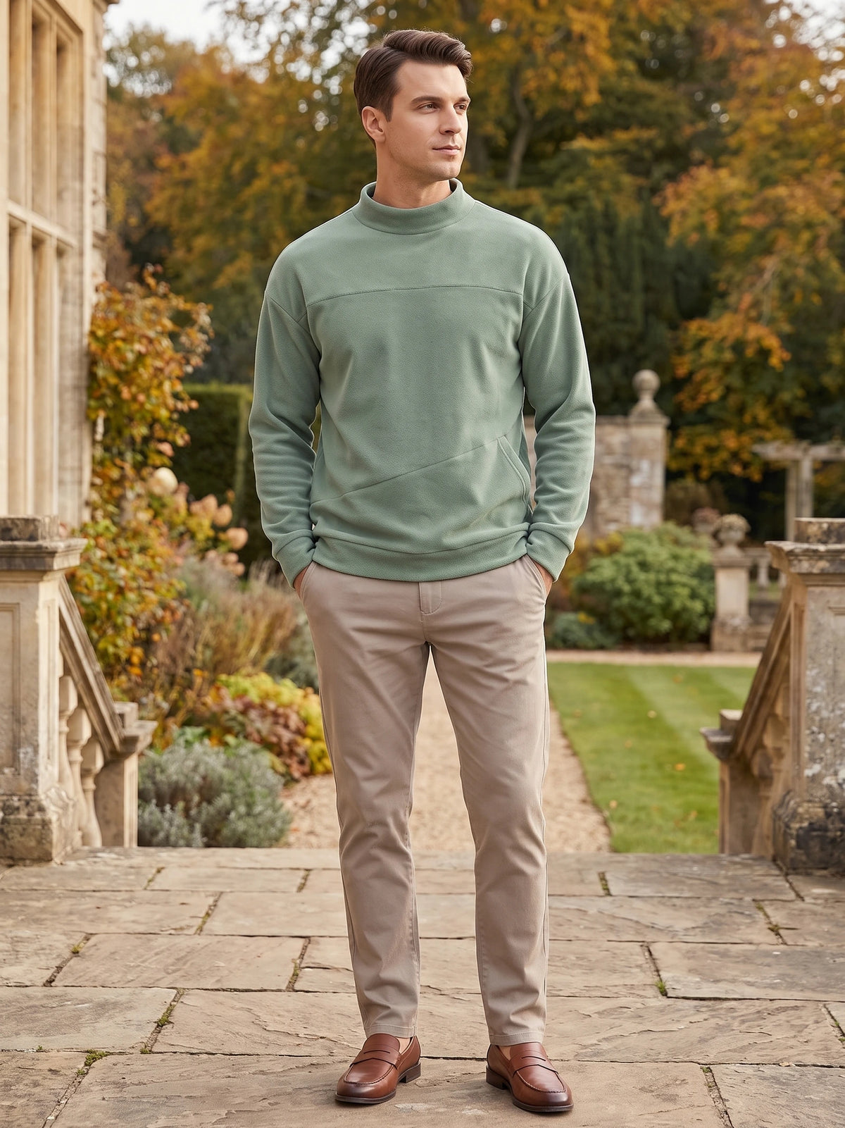 Model wearing a Green fleece sweater with a mock neck and front pocket while standing in a landscaped garden.